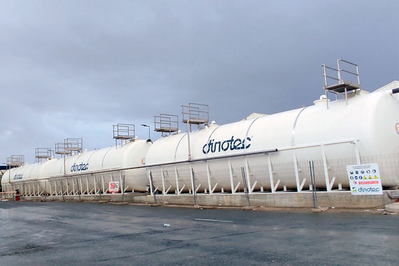 Gran depósito industrial blanco bajo cielo nublado