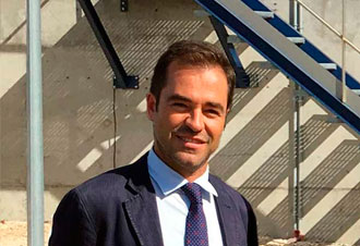 Hombre con traje junto a escaleras metálicas
