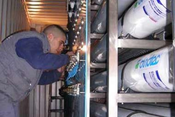 Técnico trabajando en sistema industrial con cilindros