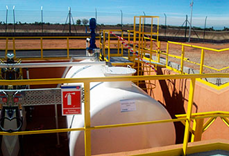 Tanque industrial blanco con barandillas amarillas