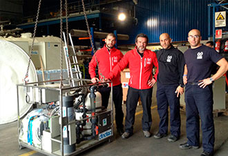 Cuatro técnicos junto a maquinaria industrial en taller