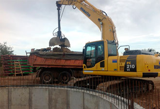 Excavadora cargando tierra en camión volquete