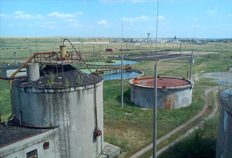 Tanques industriales en paisaje rural con estanques