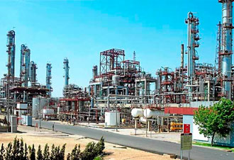 Refinería industrial con torres y tuberías metálicas
