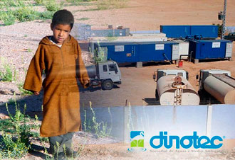 Niño junto a camiones y tanques de agua