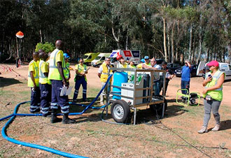 Trabajadores con chalecos reflectantes junto a equipo forestal