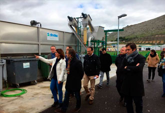 Grupo visitando planta industrial con grandes depósitos