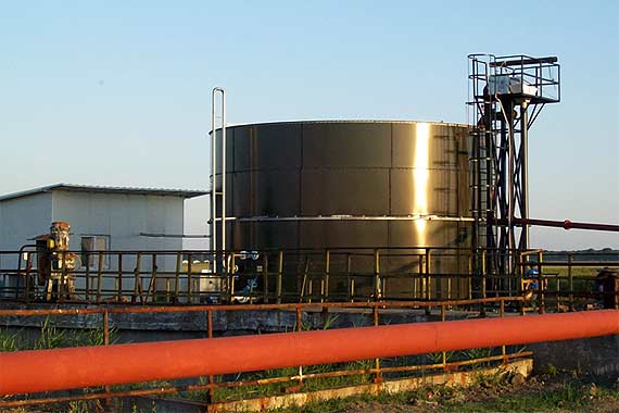 Tanque industrial metálico con tuberías exteriores
