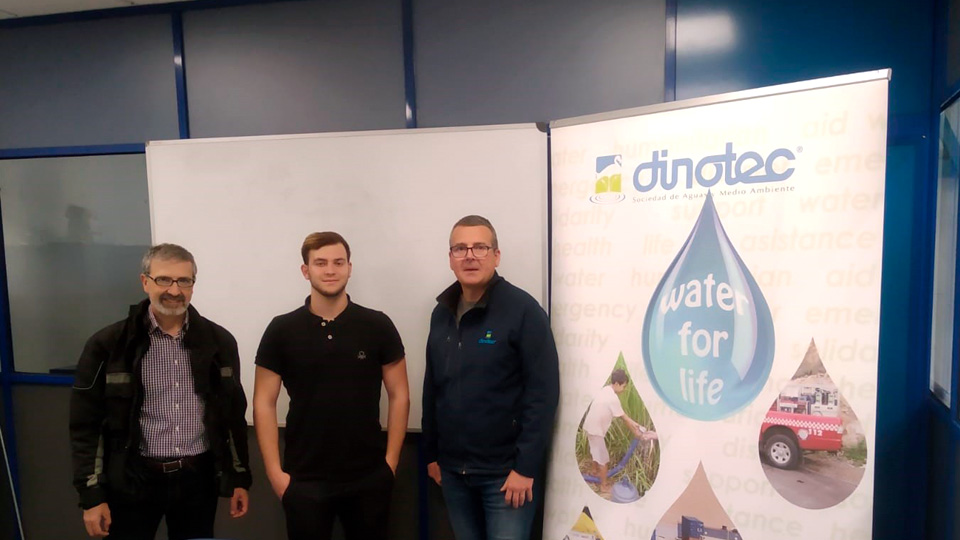 Tres hombres junto a banner corporativo dinotec
