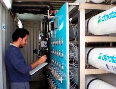 Técnico operando sistema industrial de filtración de agua