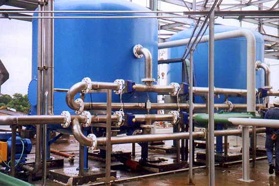 Depósitos industriales azules con tuberías metálicas