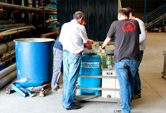 Dos hombres trabajando con maquinaria industrial en taller