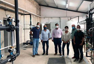 Cinco personas con mascarilla en planta industrial