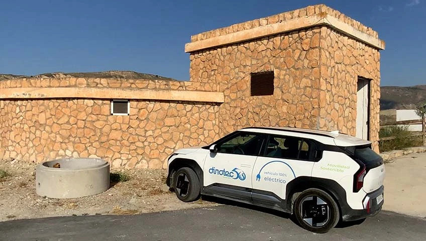 SUV eléctrico blanco junto a edificio de piedra
