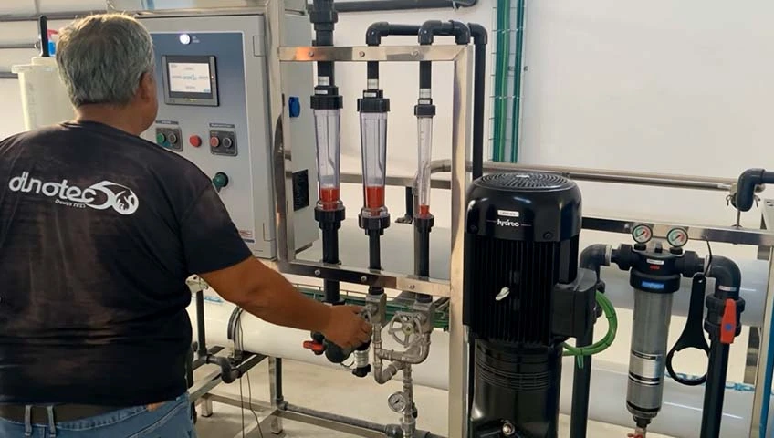 Técnico operando sistema industrial de filtración de agua